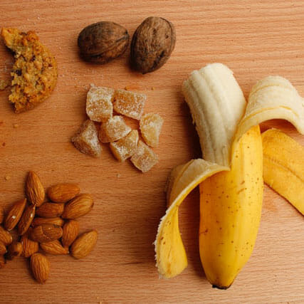 sliced banana and brown nuts on brown wooden table